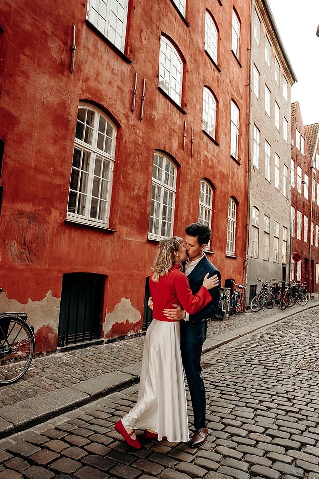 Bride and groom spinning together on a quiet Copenhagen street