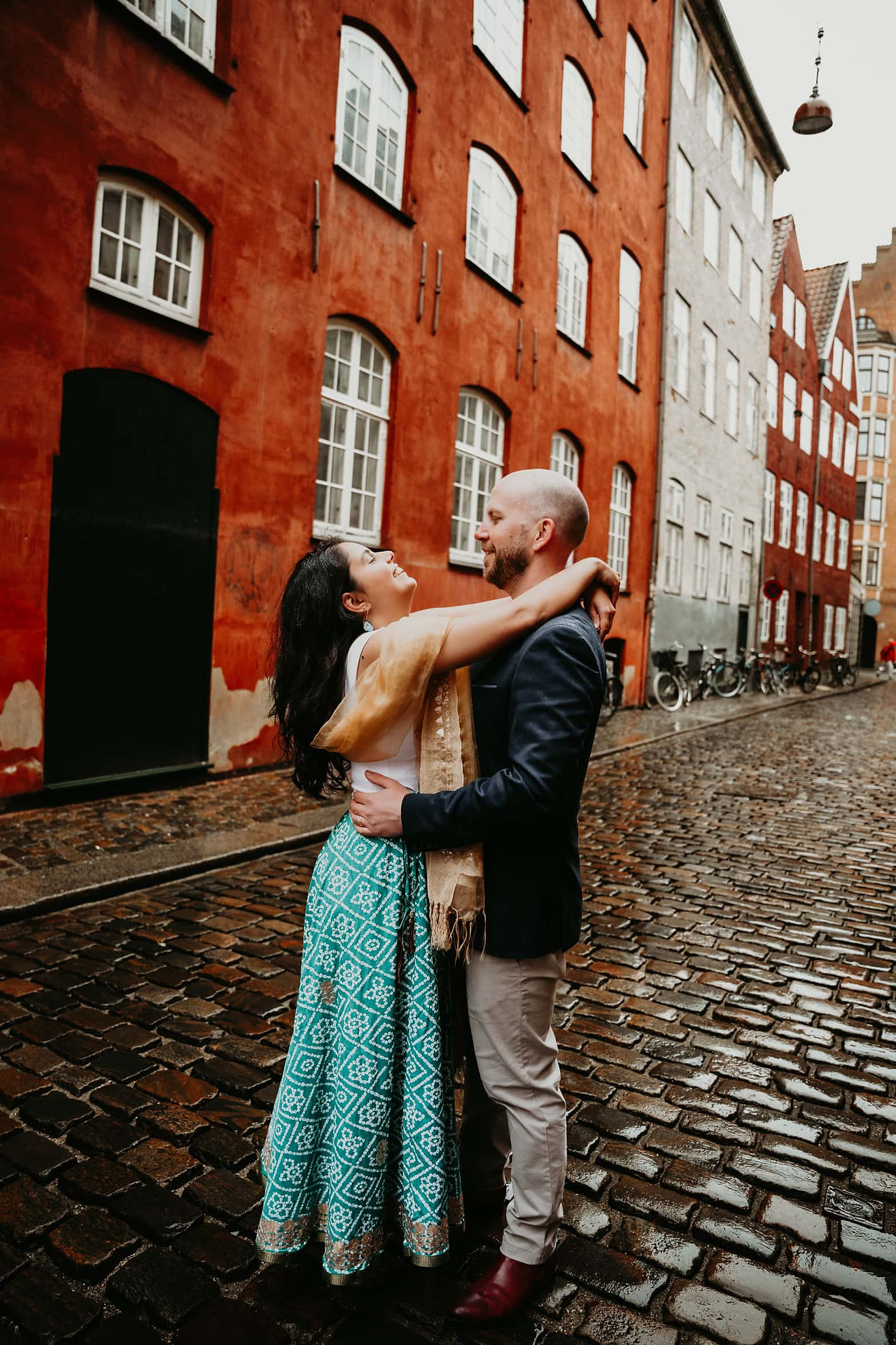 Happy couple posing for wedding photos in the street of Magstræde.