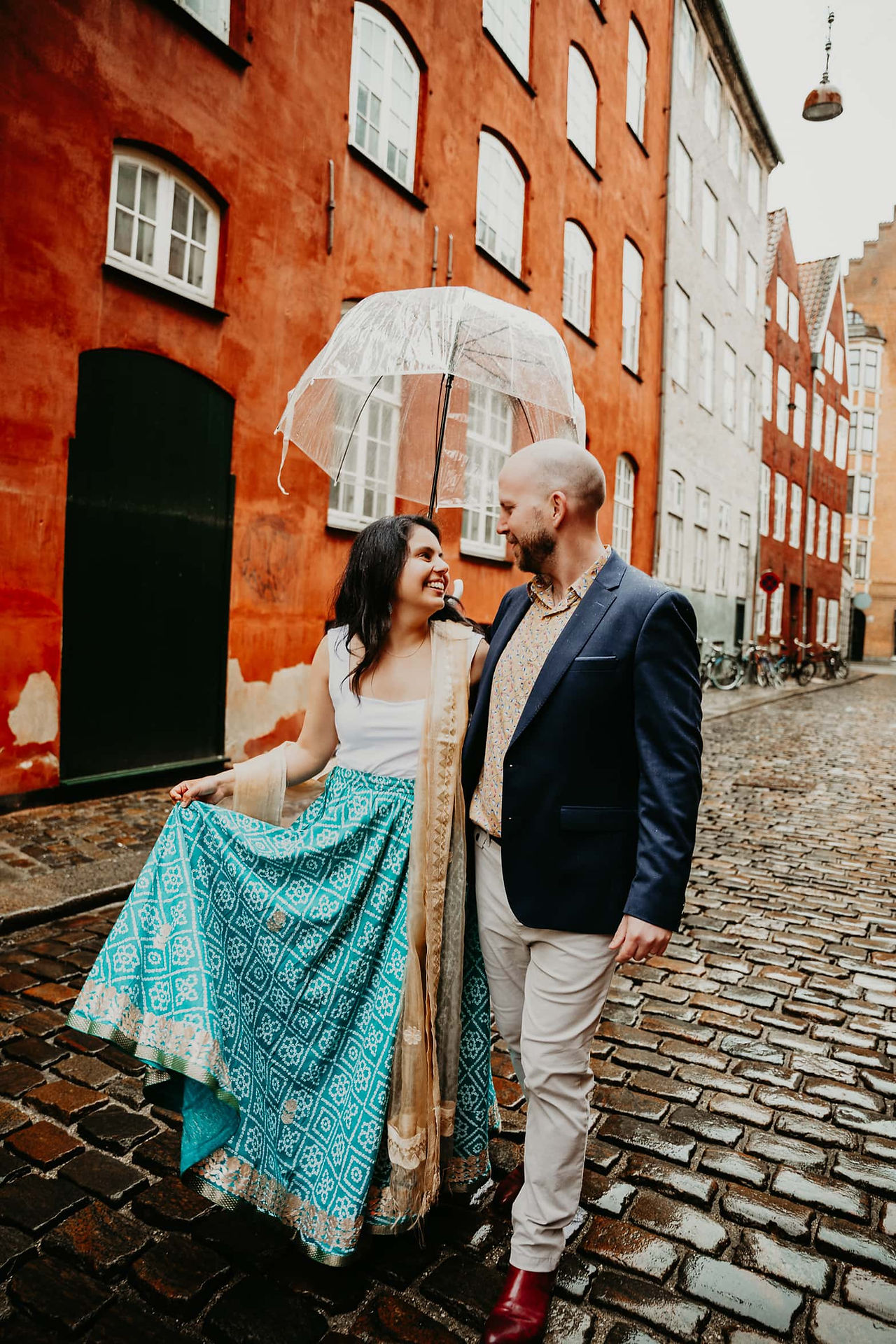 Happy couple posing for wedding photos in the street of Magstræde.