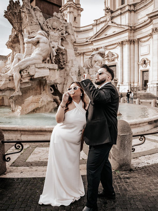 A wedding couple drinking champagne in front of the beautiful Piazza Navona