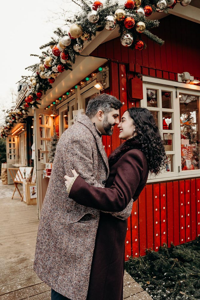 Romantic couple walking through Tivoli Gardens with Christmas decorations and snow
