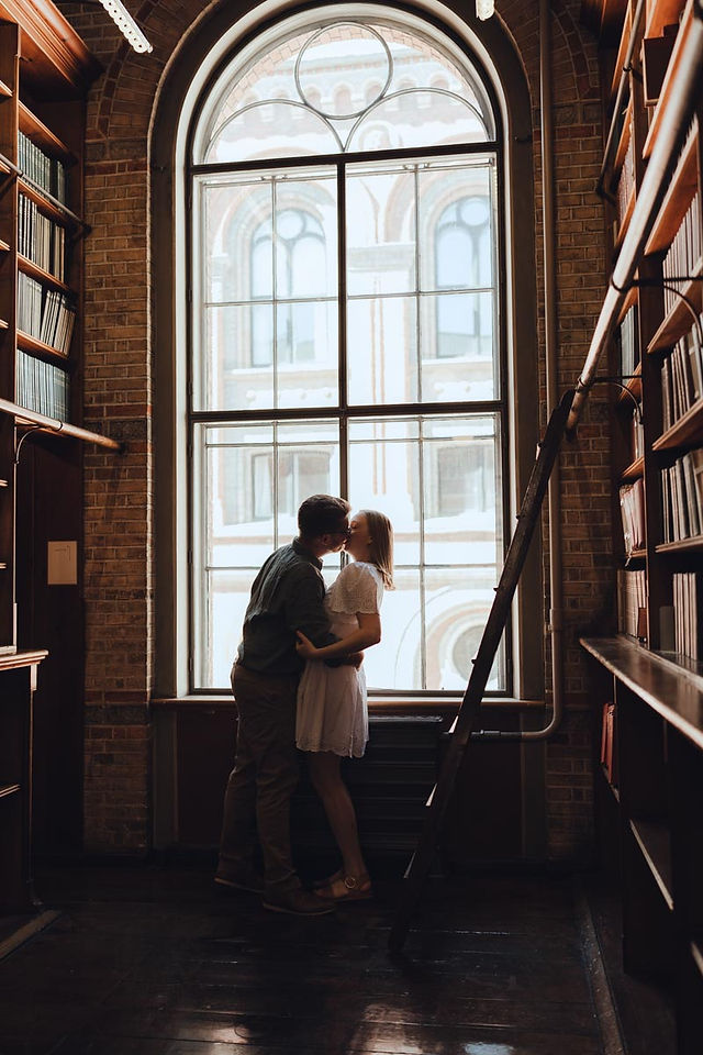 Couple lost in books during romantic photoshoot