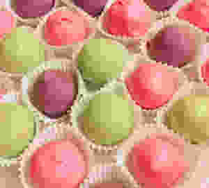 Cake balls dipped in green, purple, and pink chocolate