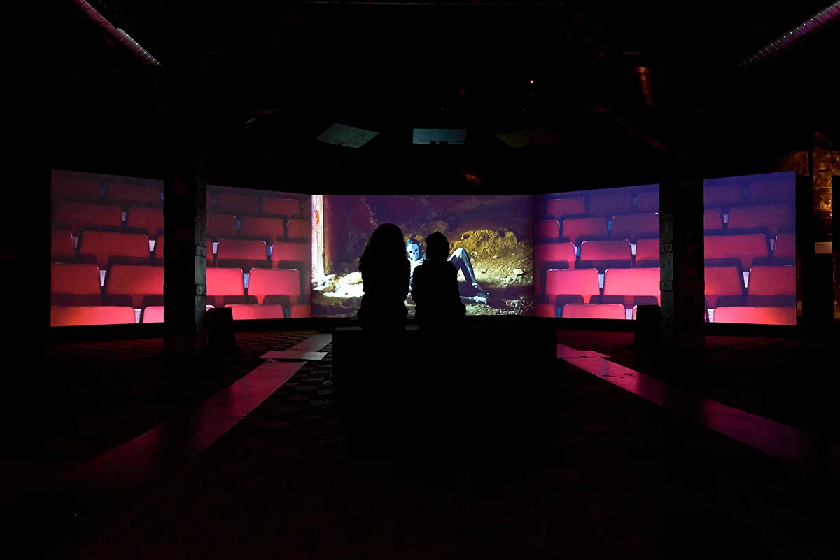Greta Alfaro Hay algo profundamente humano en el acto de ofrecer. Mostrar algo a los demás, exponerlo a la mirada ajena y convertirlo en parte de algo compartido. La artista Greta Alfaro presenta Ofertorio, una instalación site-specific concebida para la Nave 0 de Matadero Madrid que transforma el antiguo espacio industrial en un recorrido cargado de simbolismo, referencias rituales y preguntas sobre aquello que decidimos hacer visible. Integrada en la programación de PHotoESPAÑA 2026, la muestra reúne vídeos, esculturas, collages y piezas históricas en una propuesta donde la fotografía, la imagen en movimiento y la instalación dialogan para explorar conceptos como el sacrificio, la representación y la construcción de lo colectivo. Con una estética tan inquietante como fascinante, característica de la trayectoria de la artista navarra, la exposición invita a reflexionar sobre los mecanismos culturales que determinan qué cuerpos, objetos o historias ocupan el centro de la escena y cuáles permanecen fuera de campo.