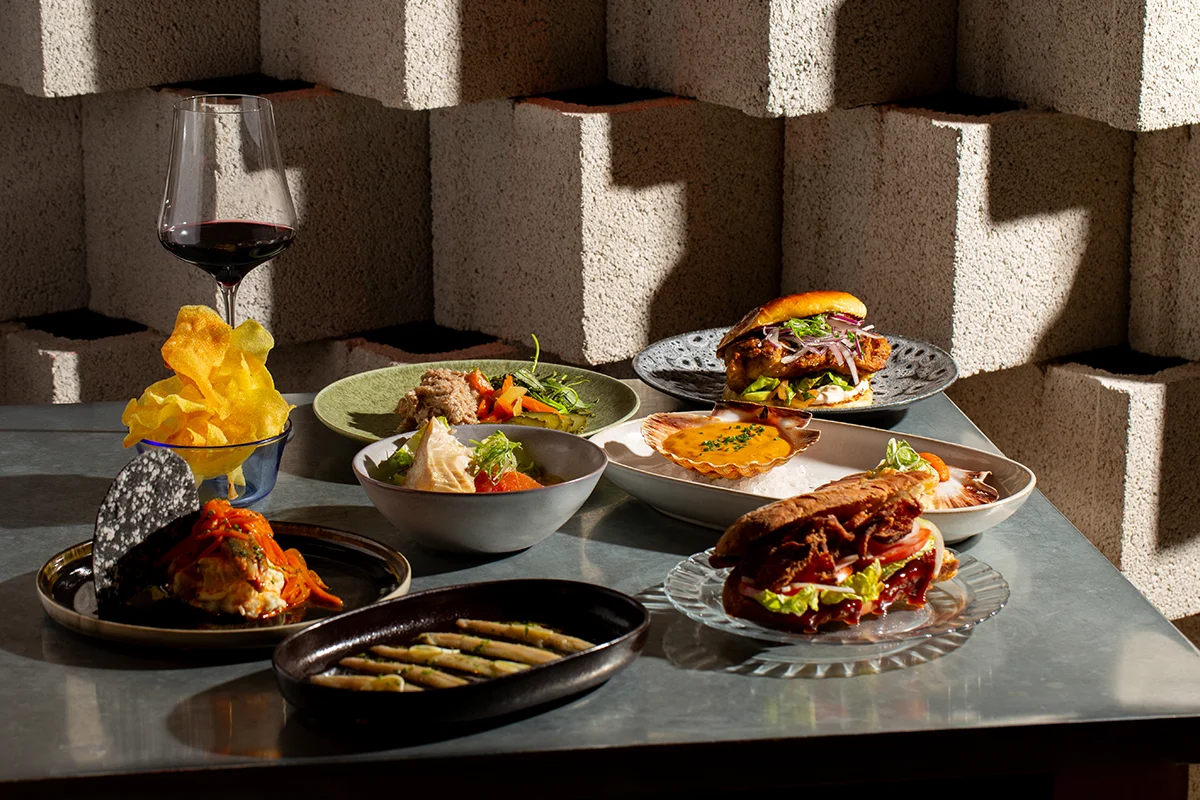 Brutalista, el restaurante de cocina española contemporánea liderado por Pablo López en el barrio madrileño de Argüelles, amplía su propuesta con una nueva franja horaria: desde esta temporada, abrirá de martes a viernes, de 18:00 a 21:00, en formato taberna. Una versión más informal y desenfadada que se articula en torno a una carta de tapas y raciones. La propuesta recupera algunos de los clásicos más reconocibles de la casa como la codorniz frita o la sardina ahumada, e incorpora nuevas propuestas como las patatas con alioli de sésamo y caballa, el montadito de pata frita o los boquerones en vinagre. También hay espacio para productos especialmente valorados, como la gamba de Huelva, siempre bajo la mirada de una cocina que reivindica el producto, la temporada y el sabor.