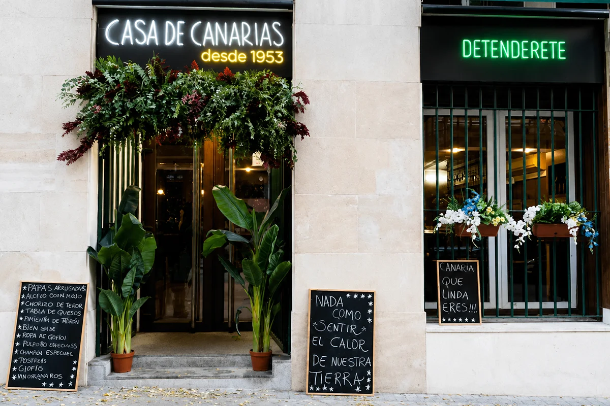 Si quieren conocer Canarias en Madrid, una inmersión segura es ir al Gastrobar Detenderete en la zona de Malasaña. Acaban de galardonarlo con un Solete en la Guía Repsol pero, fiel a sus principios, permite seguir comiendo por 25-30 euros por persona. Estos días celebra 8 años y es una apuesta por el producto canario de todas las islas con una decoración que te lleva a estar comiendo en una casa tradicional. Picoteo y buen ambiente garantizados que hacen que las tardes y las noches se alarguen al estilo canario entre una selección de productos de los más clásicos productores de las islas: vinos canarios de "toda la vida", los mejores quesos de la tierra, almogrote, papas arrugadas, pata de cerdo, ropa vieja o pulpo con mojo verde para luego endulzarte con una Ambrosía Tirma (recientemente nombrada mejor chocolatina del mundo) o un polvito uruguayo. No olvides tomarte un Clipper, una Dorada Especial fresquita o un "Carta de Oro" de Arehucas, un clásico allá donde vayas.