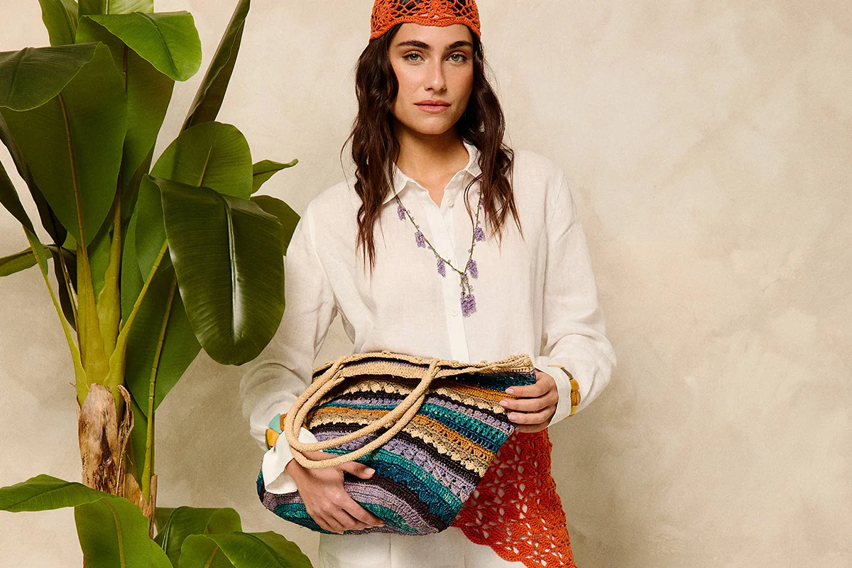 Hay marcas que no solo completan un look: lo transforman. Firmas capaces de convertir unos vaqueros básicos y una camiseta blanca en un estilismo con intención, personalidad y cierto aire aspiracional. Nombres como Pescuezo, Les Georgettes, Parfois o Foránea han encontrado precisamente ese espacio: el de las marcas que elevan cualquier outfit a través de los detalles. Porque al final, la verdadera personalidad no está en vestir de arriba abajo una marca, sino en encontrar esas piezas capaces de hacer que lo sencillo parezca pensado y personal. Los accesorios se han convertido en el lenguaje definitivo del estilo. Un collar potente, un bolso especial o una pieza artesanal bien elegida redefinen por completo la estética de quien los lleva. El auge de las firmas independientes y accesibles con fuerte identidad estética ha democratizado esa sensación de sofisticación. El secreto está en saber mezclar. Ahí es donde destacan marcas como Parfois. La firma portuguesa ha conseguido posicionarse como una referencia de accesorios de tendencia gracias a su capacidad para reinterpretar códigos minimalistas a precios asequibles. Bolsos estructurados, joyería que adorna el cuello, chaquetas y accesorios para el cabello forman parte de ese universo effortless que tanto triunfa en redes y street style. parfois.com La joyería está redefiniendo los looks. Ya no se trata únicamente de adornar, sino de aportar identidad, y Les Georgettes es uno de los ejemplos más interesantes. La firma francesa popularizó un concepto muy concreto: joyas personalizables con bandas intercambiables de cuero y vinilo. El resultado son piezas versátiles que cambian según el estado de ánimo o el look del día. Ese tipo de diseño conecta perfectamente con la moda actual, donde las consumidoras buscan piezas funcionales pero especiales. Una pulsera oversize o un brazalete arquitectónico pueden transformar instantáneamente un estilismo neutro en uno mucho más sofisticado. Además, el auge de los charms, chokers y la joyería maximalista confirma que los accesorios viven uno de sus momentos más fuertes en la industria. lesgeorgettes.com Uno de los fenómenos más interesantes de la moda reciente es el crecimiento de firmas nicho con una identidad muy marcada. En lugar de seguir tendencias masivas, estas marcas construyen su propia comunidad. Pescuezo entra dentro de esa categoría de firmas que funcionan casi como objeto de culto digital: piezas llamativas, mezcla de color, artesanía y un punto editorial que convierten cualquier look sencillo en algo mucho más interesante. Sus nuevas capas ligeras están pensadas para sobreponer y aportar un toque de estilo a los looks. Estampados Liberty, rayas —muchas rayas—, toques en amarillo limón, azules y rosas, junto a un divertido estampado de perritos, flores y los ya característicos tonos naturales, conviven en una propuesta que equilibra tradición y frescura para que los cuellos sean los protagonistas, incluso en verano. pescuezos.es Lo mismo ocurre con Foránea, cuyo atractivo reside precisamente en esa sensación de exclusividad relajada: accesorios con carácter, inspiración artesanal y estética contemporánea que encajan perfectamente con la tendencia actual hacia lo auténtico y lo imperfecto. Una nueva marca que invita a descubrir el mundo a través de la artesanía, poniendo en valor las historias, las manos y las culturas que hay detrás de cada pieza. Su universo se construye a partir de una cuidada selección de accesorios hechos a mano en distintos lugares del mundo: desde bolsos y cestas de rafia de Madagascar hasta crochet bordado en Ecuador, joyas de tagua, piezas de Turquía o textiles de la India. Cada pieza es el resultado de un proceso manual, donde el tiempo y la dedicación forman parte de su valor, apostando por una forma de consumo más consciente y especial. foranea.com