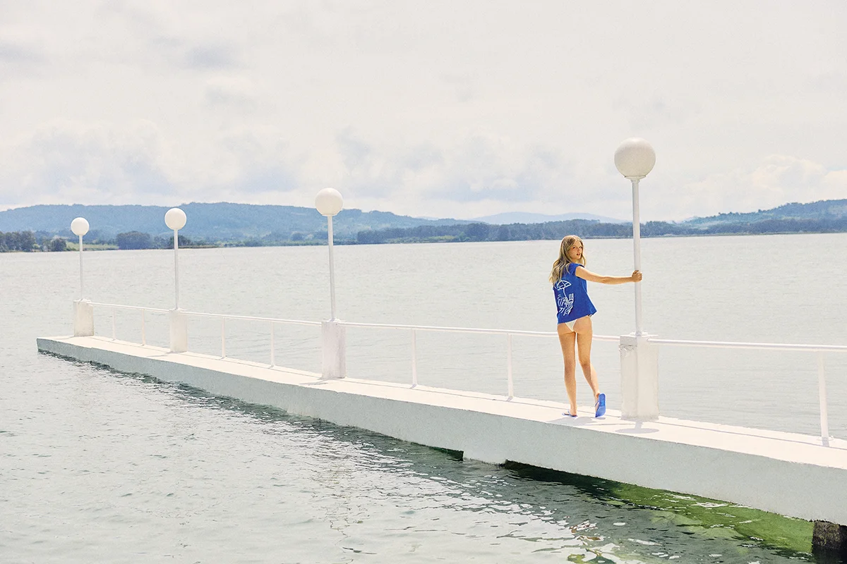Pull&Bear han encontrado en La Toja el escenario perfecto para construir ese imaginario de escapada atlántica que mezcla nostalgia, calma y estética resort. Bajo el nombre Gran Hotel La Toja, la marca convierte el icónico resort gallego en inspiración para una propuesta donde las rayas marineras, los tejidos ligeros y las siluetas fluidas marcan el ritmo. El azul royal, el blanco roto y los toques amarillos evocan la luz de la costa y ese verano pausado que parece no tener prisa con camisas oversize, shorts tipo bóxer y prendas de punto fino componen una colección fácil de llevar, pensada para un paseo por el paseo marítimo o una comida al sol sin cambiar de actitud. Más allá de la ropa, Pull&Bear construye un universo reconocible que recupera la elegancia desenfadada de los destinos clásicos de vacaciones y la traduce a un lenguaje actual, fresco y muy apetecible.
