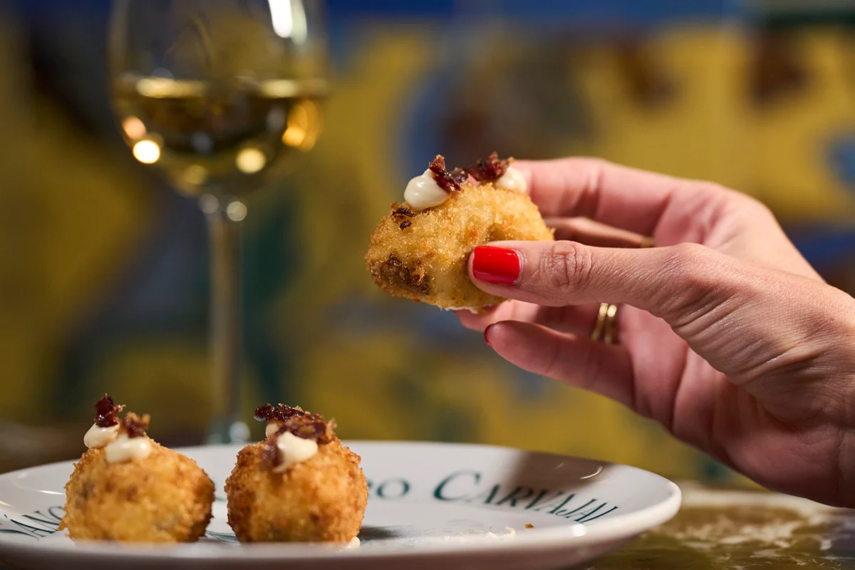 Ruta de la Croqueta de Sánchez Romero Carvajal La croqueta es uno de esos clásicos siempre presente en los mejores momentos de tapeo y terraceo. Los amantes de esta elaboración están de enhorabuena porque ya pueden disfrutar de la Ruta de la Croqueta de Sánchez Romero Carvajal, celebración que cumple su cuarta edición con una propuesta más amplia y con más fuerza que nunca. Hasta el 6 de julio, este recorrido se instala como una de las citas gastronómicas más esperadas del inicio del verano con los nuevos participantes como Salino, Los Gabrieles, Árdia, Rita Sibarita, Casa Vega, Cachivache (Serrano), La Raquetista, Cachivache (Montecarmelo) y El Gallego, que amplían el itinerario con nuevas interpretaciones de este clásico. Las incorporaciones se suman a algunos de los grandes nombres de otras ediciones como Casa Orellana, Tatel, Casa Salesas, Café Comercial, 11 Nudos, El Escondite de Villanueva o Virrey. Además, con motivo del Día Mundial de la Tapa, la ruta amplía su propuesta con una irresistible selección de tapas elaboradas con jamón ibérico.