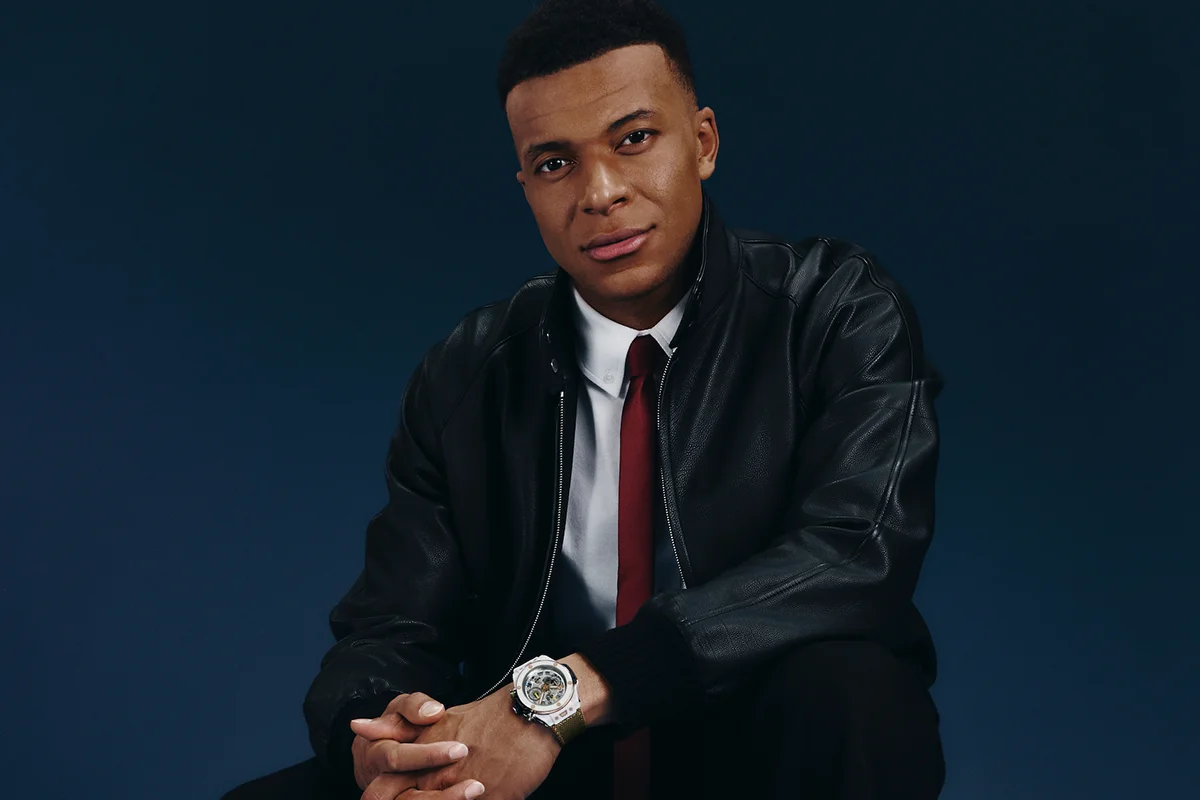 La alta relojería y el deporte de élite volvieron a encontrarse en Madrid de la mano de Hublot y Kylian Mbappé. La presentación del nuevo Big Bang Reloaded Kylian Mbappé mostraba en público una edición limitada que convierte la personalidad y ambición del futbolista en una auténtica pieza de colección limitada a solo 200 unidades. La pieza destaca por su poderosa estética contemporánea y por reflejar el ADN innovador de la manufactura suiza. Fabricado en cerámica blanca pulida y oro King Gold de 18 quilates, el modelo incorpora detalles profundamente ligados al jugador, entre ellos el grabado “Trust Yourself” en el bisel o el número 10 en tono dorado, guiño directo a su icónica camiseta y a la filosofía que ha marcado su trayectoria profesional. Más allá de su diseño, el Big Bang Reloaded Kylian Mbappé también representa la excelencia técnica de la firma. En su interior alberga el calibre UNICO, uno de los cronógrafos integrados más avanzados de la firma suiza, capaz de combinar innovación mecánica y precisión de alta relojería con una estética deportiva y sofisticada. La presentación tuvo lugar en un exclusivo evento celebrado en el centro de Madrid, reunión de figuras del deporte, la moda y el entretenimiento como la estrella de la selección francesa, Iker Casillas o Paula Echevarría, entre otros, disfrutando de música en directo, una cuidada puesta en escena y una atmósfera contemporánea que celebraba la llegada de todo un icono.