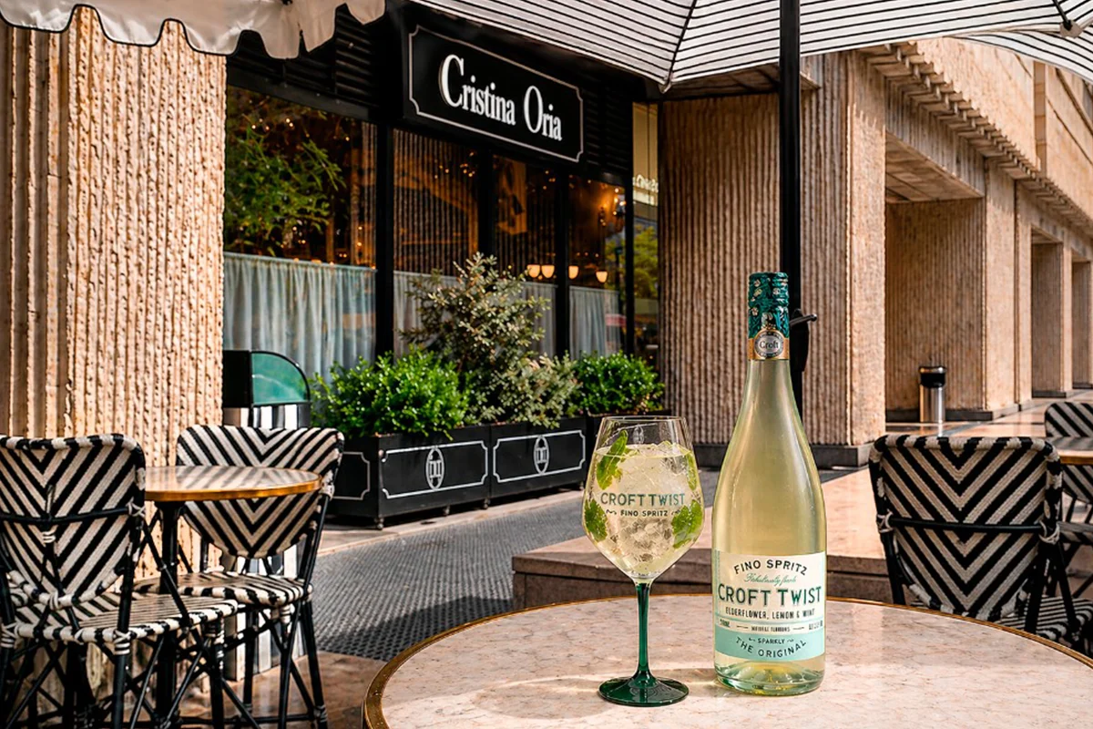 CROFT TWIST    El spritz ya no habla solo italiano, sino que ahora tiene acento andaluz. Croft Twist es una propuesta que cambia el prosecco por vino fino y convierte el aperitivo en algo más fresco, ligero y sorprendente. Con una graduación de apenas 5,5º, esta bebida se ha ganado un hueco entre quienes buscan alternativas más suaves sin renunciar al sabor ni al ritual de la copa al atardecer.      Su fórmula mezcla finos elegantes elaborados en las bodegas centenarias de González Byass con ingredientes naturales como hierbabuena y limón, dando lugar a un perfil cítrico, delicado y muy fácil de beber. La burbuja es fina, ligera y pensada para acompañar esos tardeos interminables que empiezan sin saber cuándo terminan. Croft Twist representa una nueva generación de aperitivos: menos intensos, más espontáneos y ligados a momentos sociales diurnos donde importa tanto la bebida como el ambiente que la rodea.   