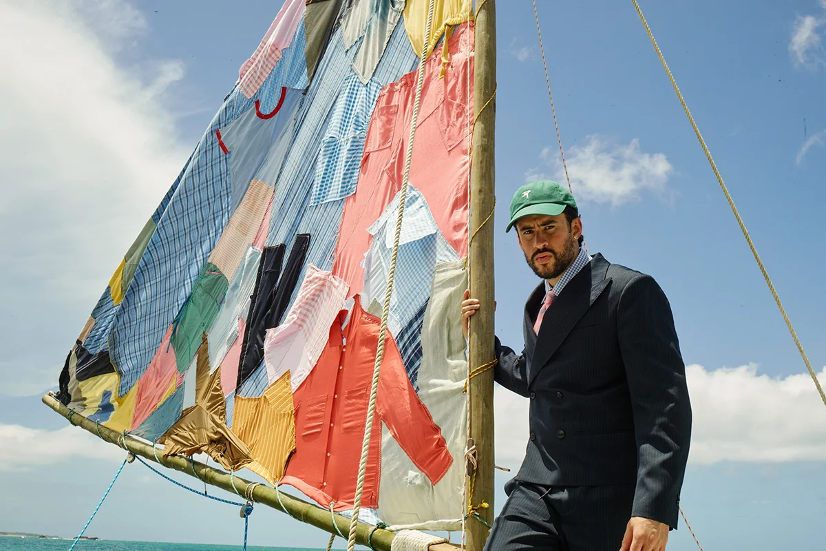 “Un verano en NUEVAYoL”… con Benito aterrizando en España. Coincidiendo con el arranque de sus conciertos en España, la marca de Inditex lanza BENITO ANTONIO, una cápsula de casi 150 piezas que traduce el universo estético del artista puertorriqueño a prendas pensadas para el día a día. Oversize, sastrería relajada, camisetas gráficas, bermudas amplias, bandanas y tejidos ligeros forman parte de una propuesta que bebe directamente de Puerto Rico y de esa manera despreocupada —pero muy medida— de vestir que define a Benito. Lejos de parecer el típico merchandising de gira, la colección funciona como una extensión real de su estilo personal: colores vibrantes, siluetas cómodas y ese punto entre urbano y nostálgico que domina también sus últimos trabajos musicales. Además, llega en uno de los momentos de mayor locura, con fans agotando prendas en cuestión de horas y preparando looks para los conciertos de Madrid y Barcelona.