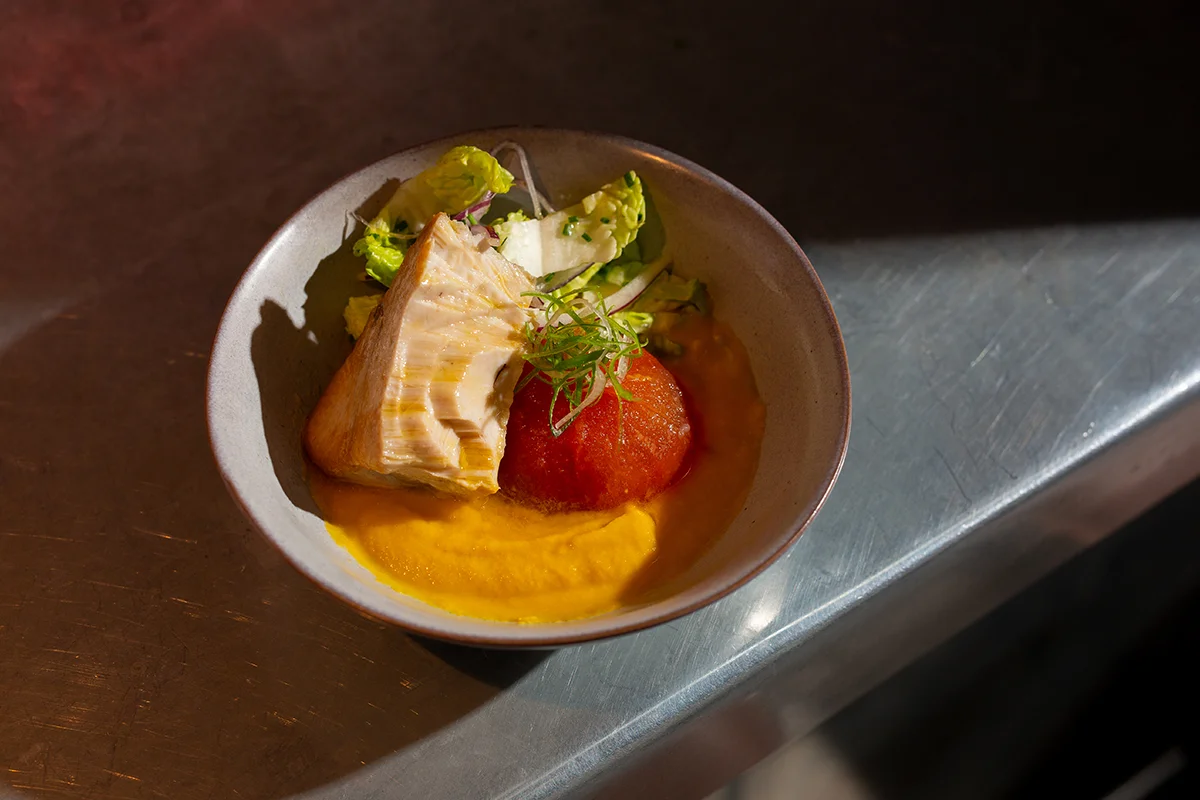 Brutalista, el restaurante de cocina española contemporánea liderado por Pablo López en el barrio madrileño de Argüelles, amplía su propuesta con una nueva franja horaria: desde esta temporada, abrirá de martes a viernes, de 18:00 a 21:00, en formato taberna. Una versión más informal y desenfadada que se articula en torno a una carta de tapas y raciones. La propuesta recupera algunos de los clásicos más reconocibles de la casa como la codorniz frita o la sardina ahumada, e incorpora nuevas propuestas como las patatas con alioli de sésamo y caballa, el montadito de pata frita o los boquerones en vinagre. También hay espacio para productos especialmente valorados, como la gamba de Huelva, siempre bajo la mirada de una cocina que reivindica el producto, la temporada y el sabor.