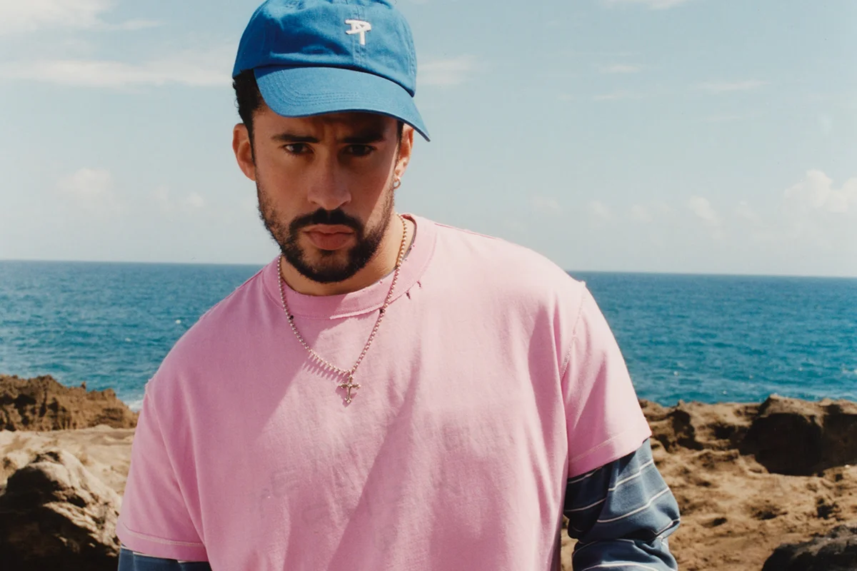 “Un verano en NUEVAYoL”… con Benito aterrizando en España. Coincidiendo con el arranque de sus conciertos en España, la marca de Inditex lanza BENITO ANTONIO, una cápsula de casi 150 piezas que traduce el universo estético del artista puertorriqueño a prendas pensadas para el día a día. Oversize, sastrería relajada, camisetas gráficas, bermudas amplias, bandanas y tejidos ligeros forman parte de una propuesta que bebe directamente de Puerto Rico y de esa manera despreocupada —pero muy medida— de vestir que define a Benito. Lejos de parecer el típico merchandising de gira, la colección funciona como una extensión real de su estilo personal: colores vibrantes, siluetas cómodas y ese punto entre urbano y nostálgico que domina también sus últimos trabajos musicales. Además, llega en uno de los momentos de mayor locura, con fans agotando prendas en cuestión de horas y preparando looks para los conciertos de Madrid y Barcelona.