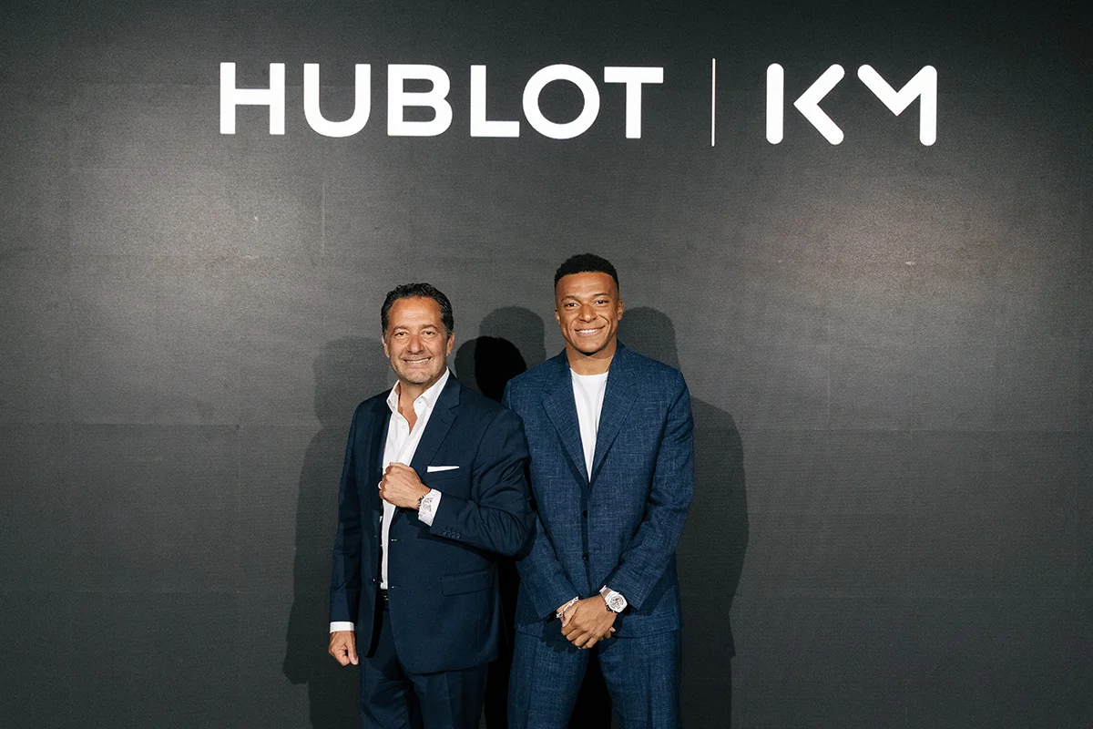 La alta relojería y el deporte de élite volvieron a encontrarse en Madrid de la mano de Hublot y Kylian Mbappé. La presentación del nuevo Big Bang Reloaded Kylian Mbappé mostraba en público una edición limitada que convierte la personalidad y ambición del futbolista en una auténtica pieza de colección limitada a solo 200 unidades. La pieza destaca por su poderosa estética contemporánea y por reflejar el ADN innovador de la manufactura suiza. Fabricado en cerámica blanca pulida y oro King Gold de 18 quilates, el modelo incorpora detalles profundamente ligados al jugador, entre ellos el grabado “Trust Yourself” en el bisel o el número 10 en tono dorado, guiño directo a su icónica camiseta y a la filosofía que ha marcado su trayectoria profesional. Más allá de su diseño, el Big Bang Reloaded Kylian Mbappé también representa la excelencia técnica de la firma. En su interior alberga el calibre UNICO, uno de los cronógrafos integrados más avanzados de la firma suiza, capaz de combinar innovación mecánica y precisión de alta relojería con una estética deportiva y sofisticada. La presentación tuvo lugar en un exclusivo evento celebrado en el centro de Madrid, reunión de figuras del deporte, la moda y el entretenimiento como la estrella de la selección francesa, Iker Casillas o Paula Echevarría, entre otros, disfrutando de música en directo, una cuidada puesta en escena y una atmósfera contemporánea que celebraba la llegada de todo un icono.