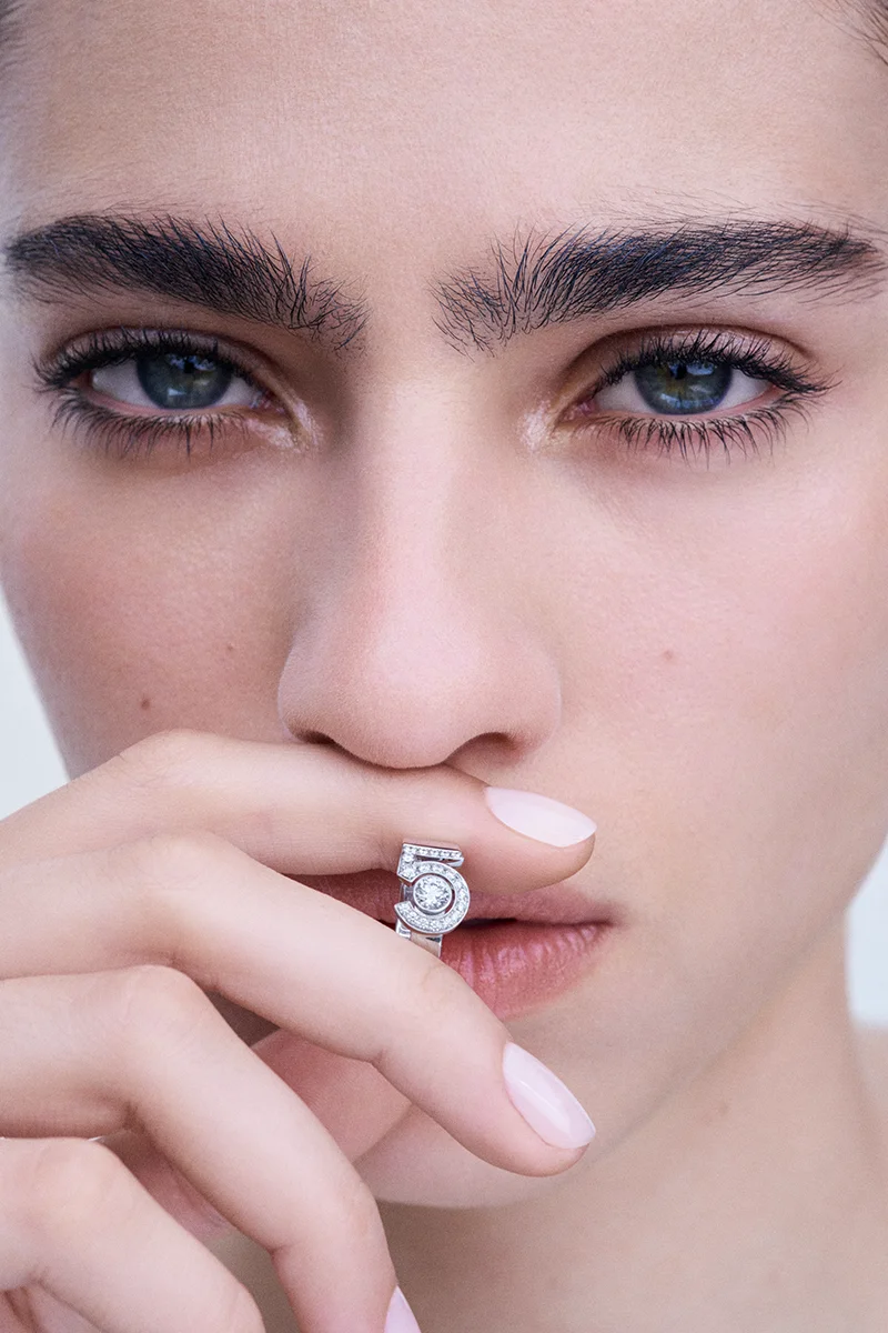 “Un magnético conjunto de joyería donde la pureza de la línea de diamantes se reinventa en una expresión poderosa y asertiva, bajo la firma del icónico N°5”.  Así resume la flamante enseña cómo su excepcional savoir-faire está detrás de la creación de piezas emblemáticas.      Haciéndose eco de la visionaria colección "Bijoux de Diamants" presentada por Gabrielle Chanel en 1932, esta colección N°5 transforma el icono del perfume creado en 1921 por Ernest Beaux en un icono joyero. Cien años después, como celebración de su éxito, CHANEL dedicaba a la fragancia una excepcional colección de Alta Joyería que incluye la obra maestra del collar 55.55, engastado con un diamante de 55,55 quilates de extraordinaria pureza.      El ejercicio del 2025 pasado observaba la transformación de los códigos del N°5. Oro y diamantes lucían sobre dos creaciones, un collar más corto que puede ajustarse como gargantilla -resaltando su feminidad, en línea con el lenguaje estilístico iniciado por Gabrielle Chanel en 1932- y una pulsera adornada con los tres colores del oro (blanco, BEIGE y amarillo), cuyo cierre invisible se oculta en el corazón del legendario número, imitando la apertura del icónico cierre del 2.55. Ambas piezas van acompañadas de nuevas versiones en oro amarillo de una pulsera rígida, un anillo y un pendiente individual.     Inspirados en el diseño del collar 55.55, collar y pulsera describen su emblemática belleza desde el contraste del conjunto: una línea de diamantes redondos, la firma del número 5 y el diamante central con engaste cerrado y una preciosa y sensual gota. Una metáfora que acaricia la piel como solo CHANEL hace desde sus comienzos.  