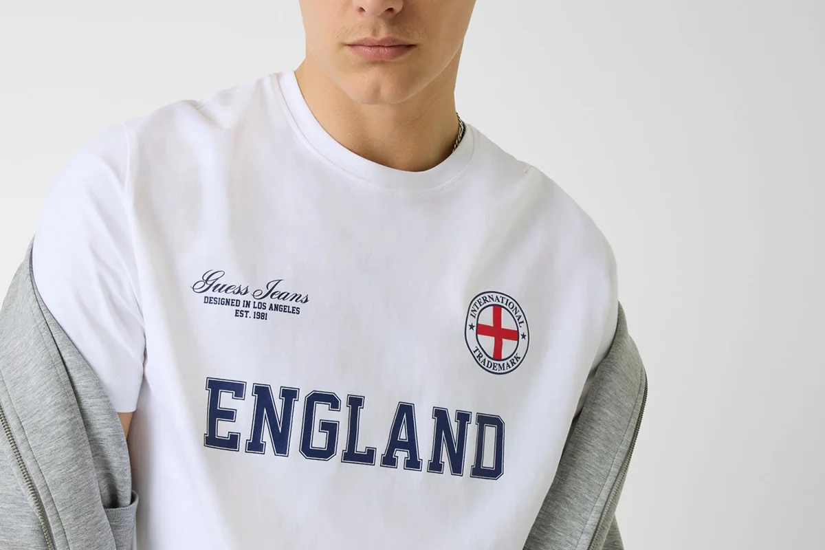 GUESS JEANS celebra la pasión por el fútbol y se fija en las selecciones más icónicas del mundo, entre ellas, España. Con diseños que permiten mostrar el orgullo nacional a través de prendas frescas, cómodas y con el sello inconfundible de la marca, la iniciativa forma parte de la colección Nation, una propuesta que rinde homenaje al espíritu futbolero internacional desde una perspectiva moderna y desenfadada. Con esta colección, la firma anima a los aficionados a vestir los colores de su selección y a apoyar al equipo dentro y fuera del terreno de juego, demostrando que el fútbol también puede ser una declaración de estilo.