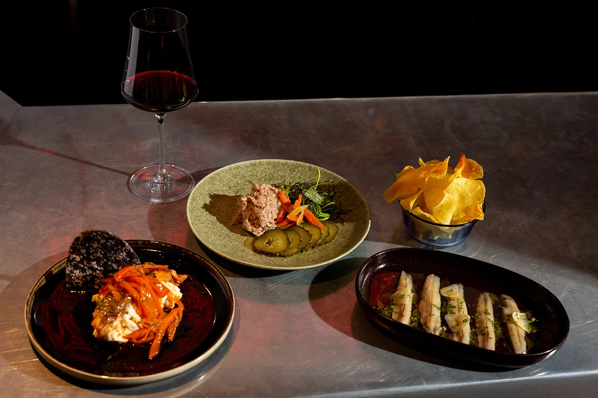 Brutalista, el restaurante de cocina española contemporánea liderado por Pablo López en el barrio madrileño de Argüelles, amplía su propuesta con una nueva franja horaria: desde esta temporada, abrirá de martes a viernes, de 18:00 a 21:00, en formato taberna. Una versión más informal y desenfadada que se articula en torno a una carta de tapas y raciones. La propuesta recupera algunos de los clásicos más reconocibles de la casa como la codorniz frita o la sardina ahumada, e incorpora nuevas propuestas como las patatas con alioli de sésamo y caballa, el montadito de pata frita o los boquerones en vinagre. También hay espacio para productos especialmente valorados, como la gamba de Huelva, siempre bajo la mirada de una cocina que reivindica el producto, la temporada y el sabor.