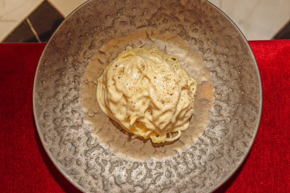 Trebbiano No hace falta viajar a Italia para comer una buena pasta cuando Madrid recibe a Trebbiano, un nuevo restaurante con el foco puesto en el recetario de Abruzzo, una de las regiones más auténticas y menos exploradas del país. Su propuesta huye del artificio para recuperar una cocina honesta, reconocible y profundamente ligada al producto, donde la tradición no se replica, sino que se reinterpreta con respeto. Detrás del proyecto están los hermanos Maurizio y Stefano Ruggeri, que trasladan a tu plato la herencia hostelera de su familia junto a una visión contemporánea de la gastronomía italiana. El nombre del restaurante, inspirado en una variedad de uva típica de su región de origen, funciona como declaración de intenciones: volver a las raíces sin renunciar a la evolución.
