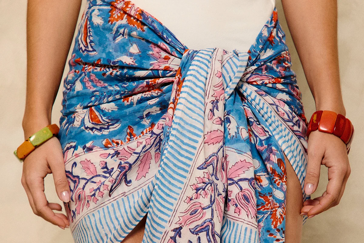 Hay marcas que no solo completan un look: lo transforman. Firmas capaces de convertir unos vaqueros básicos y una camiseta blanca en un estilismo con intención, personalidad y cierto aire aspiracional. Nombres como Pescuezo, Les Georgettes, Parfois o Foránea han encontrado precisamente ese espacio: el de las marcas que elevan cualquier outfit a través de los detalles. Porque al final, la verdadera personalidad no está en vestir de arriba abajo una marca, sino en encontrar esas piezas capaces de hacer que lo sencillo parezca pensado y personal. Los accesorios se han convertido en el lenguaje definitivo del estilo. Un collar potente, un bolso especial o una pieza artesanal bien elegida redefinen por completo la estética de quien los lleva. El auge de las firmas independientes y accesibles con fuerte identidad estética ha democratizado esa sensación de sofisticación. El secreto está en saber mezclar. Ahí es donde destacan marcas como Parfois. La firma portuguesa ha conseguido posicionarse como una referencia de accesorios de tendencia gracias a su capacidad para reinterpretar códigos minimalistas a precios asequibles. Bolsos estructurados, joyería que adorna el cuello, chaquetas y accesorios para el cabello forman parte de ese universo effortless que tanto triunfa en redes y street style. parfois.com La joyería está redefiniendo los looks. Ya no se trata únicamente de adornar, sino de aportar identidad, y Les Georgettes es uno de los ejemplos más interesantes. La firma francesa popularizó un concepto muy concreto: joyas personalizables con bandas intercambiables de cuero y vinilo. El resultado son piezas versátiles que cambian según el estado de ánimo o el look del día. Ese tipo de diseño conecta perfectamente con la moda actual, donde las consumidoras buscan piezas funcionales pero especiales. Una pulsera oversize o un brazalete arquitectónico pueden transformar instantáneamente un estilismo neutro en uno mucho más sofisticado. Además, el auge de los charms, chokers y la joyería maximalista confirma que los accesorios viven uno de sus momentos más fuertes en la industria. lesgeorgettes.com Uno de los fenómenos más interesantes de la moda reciente es el crecimiento de firmas nicho con una identidad muy marcada. En lugar de seguir tendencias masivas, estas marcas construyen su propia comunidad. Pescuezo entra dentro de esa categoría de firmas que funcionan casi como objeto de culto digital: piezas llamativas, mezcla de color, artesanía y un punto editorial que convierten cualquier look sencillo en algo mucho más interesante. Sus nuevas capas ligeras están pensadas para sobreponer y aportar un toque de estilo a los looks. Estampados Liberty, rayas —muchas rayas—, toques en amarillo limón, azules y rosas, junto a un divertido estampado de perritos, flores y los ya característicos tonos naturales, conviven en una propuesta que equilibra tradición y frescura para que los cuellos sean los protagonistas, incluso en verano. pescuezos.es Lo mismo ocurre con Foránea, cuyo atractivo reside precisamente en esa sensación de exclusividad relajada: accesorios con carácter, inspiración artesanal y estética contemporánea que encajan perfectamente con la tendencia actual hacia lo auténtico y lo imperfecto. Una nueva marca que invita a descubrir el mundo a través de la artesanía, poniendo en valor las historias, las manos y las culturas que hay detrás de cada pieza. Su universo se construye a partir de una cuidada selección de accesorios hechos a mano en distintos lugares del mundo: desde bolsos y cestas de rafia de Madagascar hasta crochet bordado en Ecuador, joyas de tagua, piezas de Turquía o textiles de la India. Cada pieza es el resultado de un proceso manual, donde el tiempo y la dedicación forman parte de su valor, apostando por una forma de consumo más consciente y especial. foranea.com