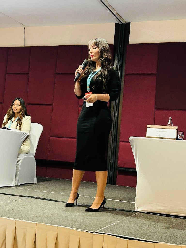 Vanessa on stage with a microphone educating the delegates on selling skills in aesthetics