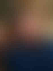 a glamorous portrait of a Woman sitting at on a couch with beautiful grey eyes. The light making her hair and face glow. Taken at the Kaspers Ghost Studio in Valparaiso, IN