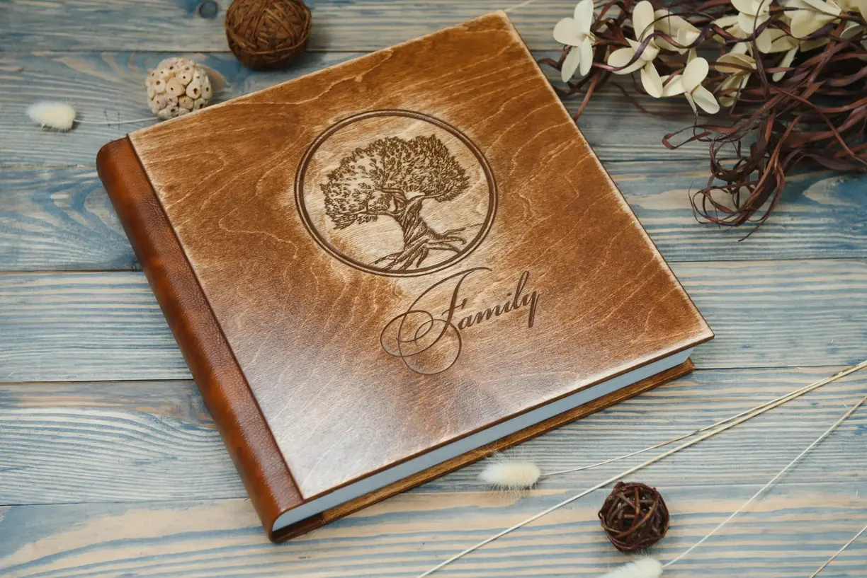 Brown leather book with symbol of tree and black engraved lettering as a family tree gift idea keepsake and unique to last for year round enjoyment on milestone birthday for mom or for dad or brother as family project to work on together