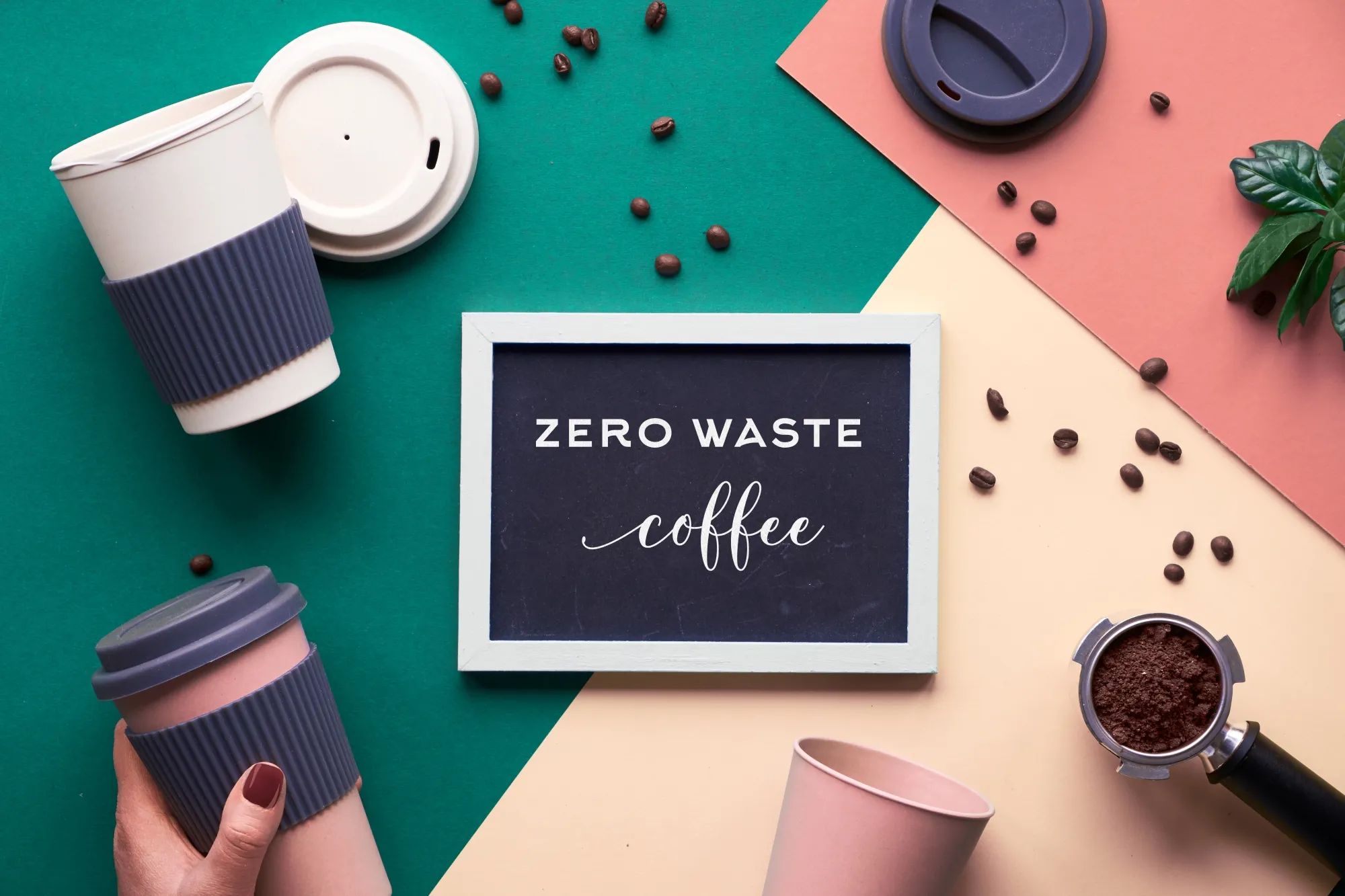 Reusable coffee cubs made of durable plastic in red and white colors with grey non slip grips on multi color background with coffee beans around a black and white sign for an eco friendly gift and sustainable as not cheap and will useable for many seasons