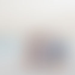 Family of seven smiling and embracing on a sandy beach in Aruba with turquoise sea and a pastel sky. They wear casual summer clothes.