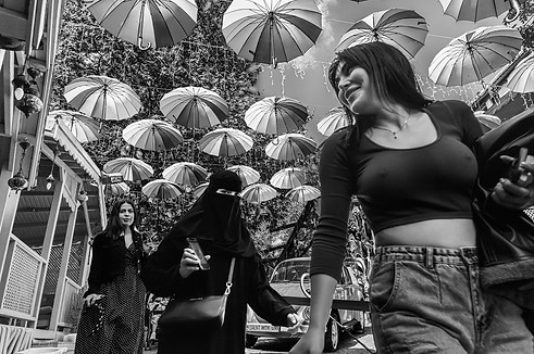 Tres jóvenes en Estambul: una de ellas con niqab junto a otras dos con vestimenta occidental en una zona de moda.