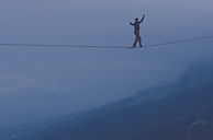 a person on a tightrope over a gauge