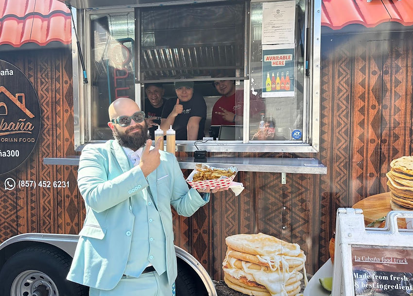 Owner serving customers authentic Mexican tacos from La Cabaña Sabores Latinos food truck service window