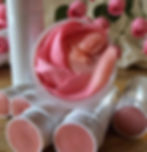 Lip balm tubes without cap containing pink, shimmer lip balm.