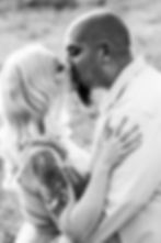 Blonde woman with tattoos kissing man with beard
