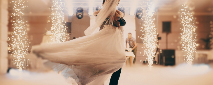 groom and bride dancing in fog and lights