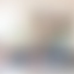 Two smiling women in a bright kitchen, one holding a blue mug, the other a phone. Plant on windowsill, cozy and cheerful atmosphere.