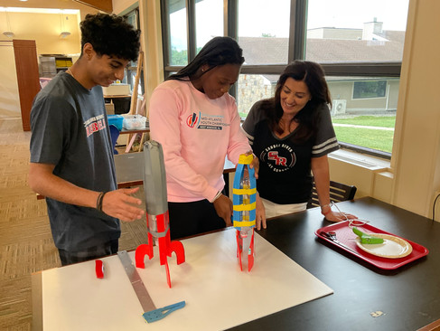 high school children working on science project with rockets