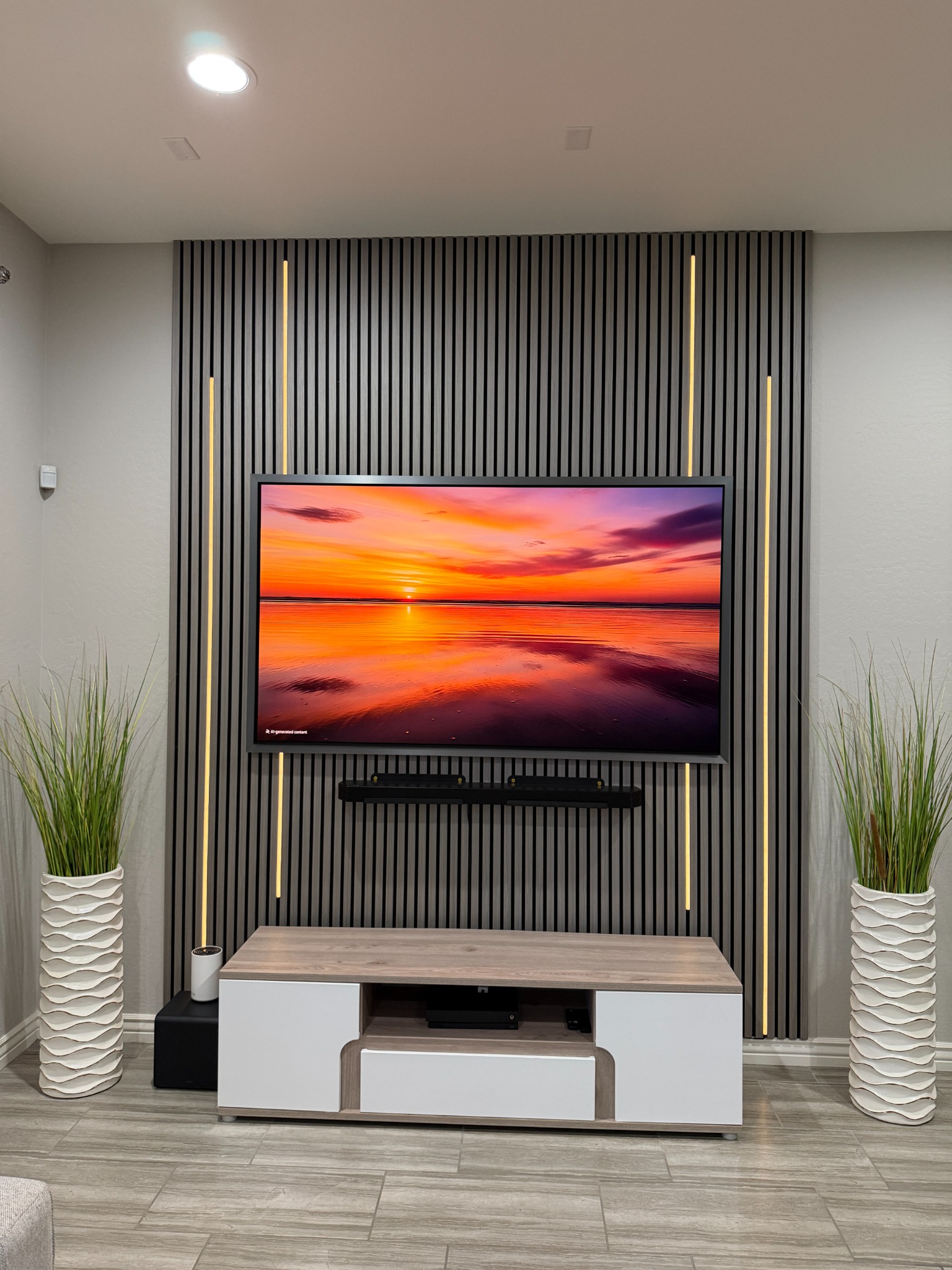 Charcoal acoustic slat wood wall panels used for a TV accent wall with vertical LED light strips