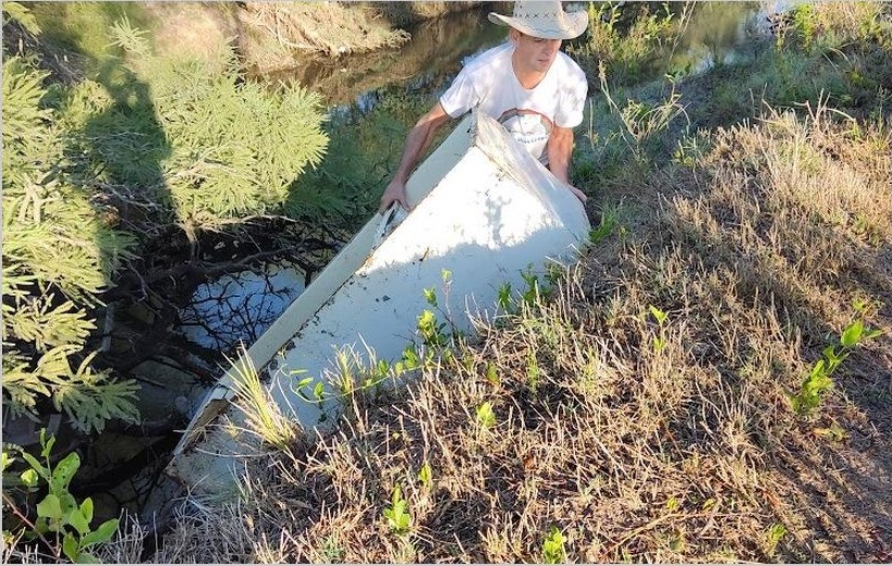 Voluntario retirando un residuo voluminoso de las márgenes del arroyo