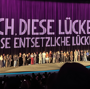 In einem großen Kinosaal stehen viele Personen auf der Bühne zu der Premiere von Ach diese Lücke, diese entsetzliche Lücke