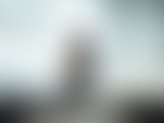 eine Frau sitzt in einem weißen Raum traurig auf einem Stuhl