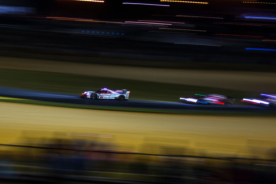 Race cars on track at night with blurred background