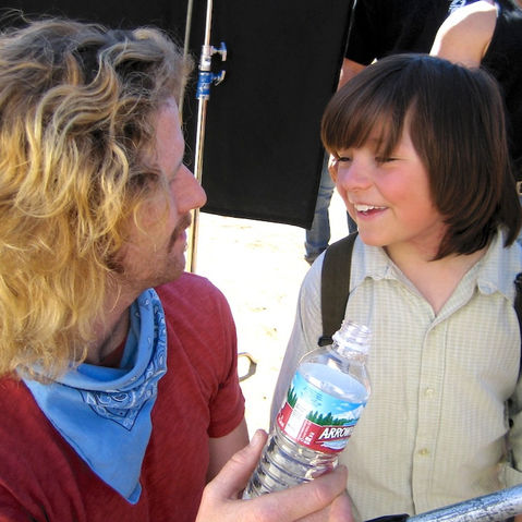 Film crew talking to child actor.