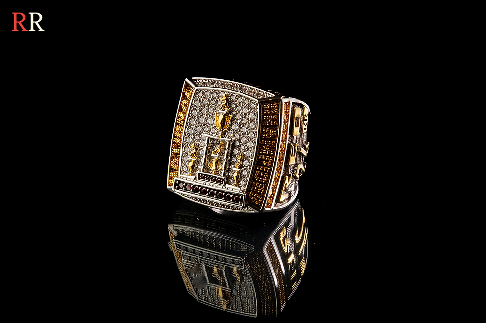 Close-up of a custom championship ring with gold and diamond details on black background, Red’s Rings jewelry collection.
