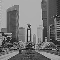crowded traffic around welcoming statue_