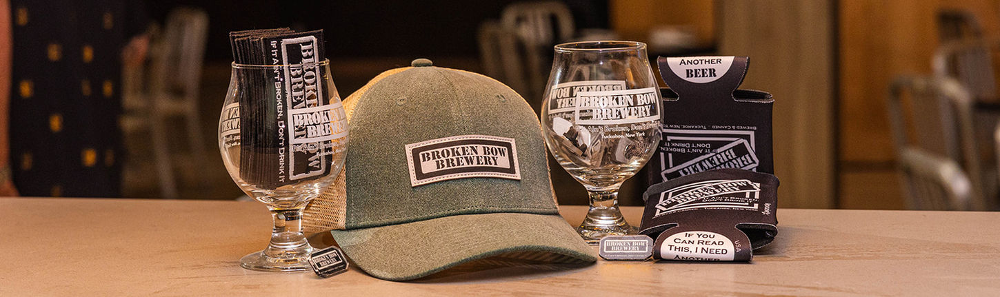 Broken Bow Brewery branded merchandise displayed on the bar, including a baseball cap, pint glasses, and apparel available for purchase.