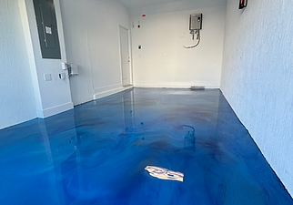 Pompano garage featuring a custom metallic epoxy floor with a bold, high-gloss marbled finish in deep blue and silver