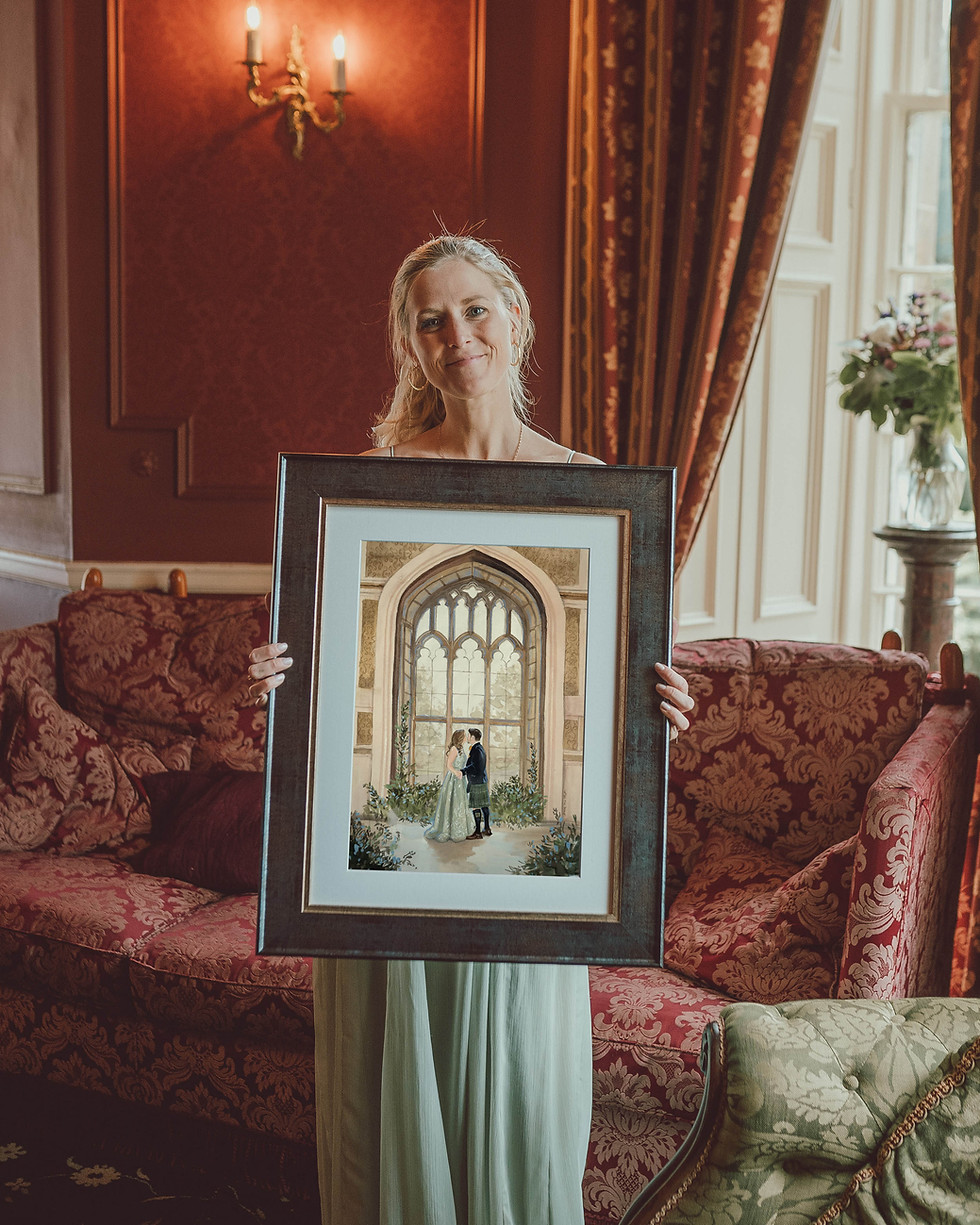 Daria van Vliet holding a framed wedding painting infant of red background