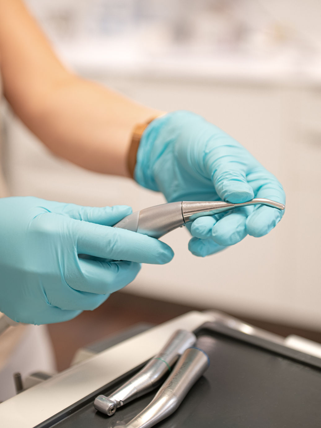 Zahnarzt hält medizinisches Gerät, Handschuhe, Zahnarztpraxis, medizinische Versorgung, Werkzeug, Nahaufnahme.