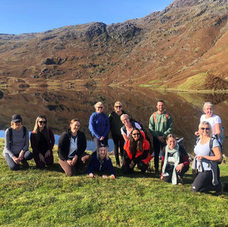 group standing in front of lake in sunshine